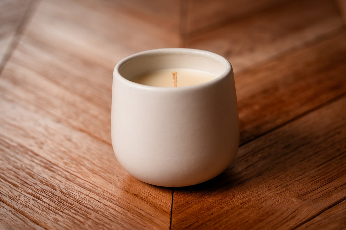 White ceramic organic candle on a wooden surface