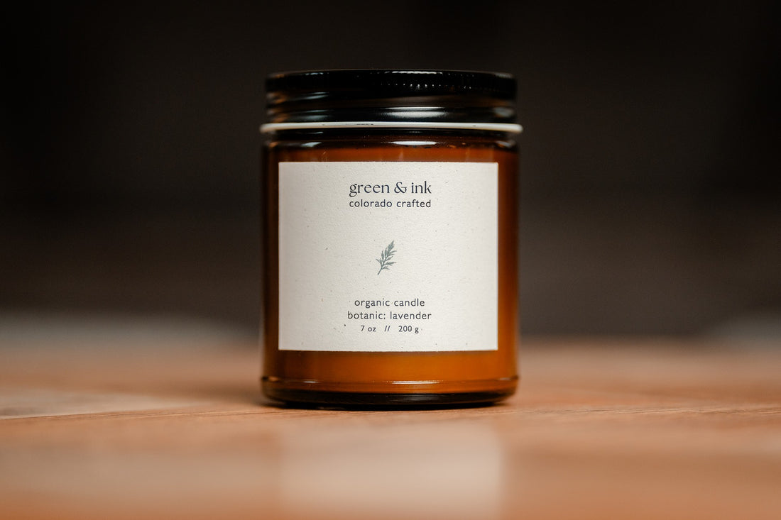 Organic candle in an amber jar with a white label &