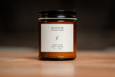 Organic candle in an amber jar with a white label &