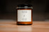 Organic candle in an amber jar with a white label &