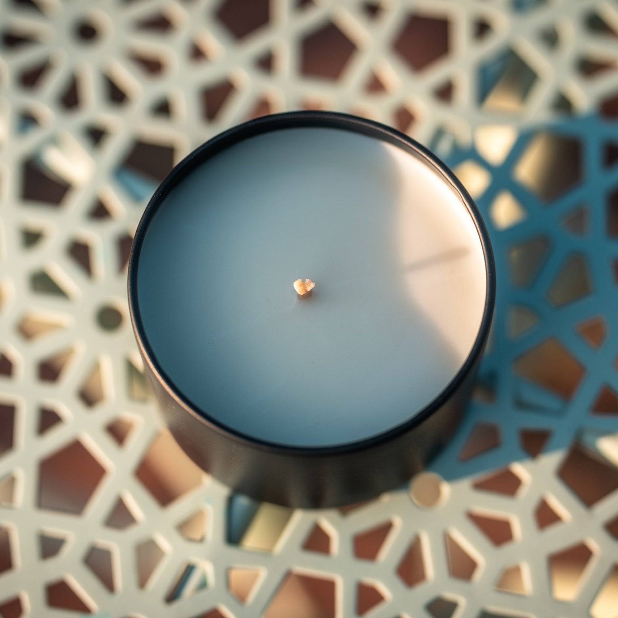 Black organic candle on a blue decorative surface