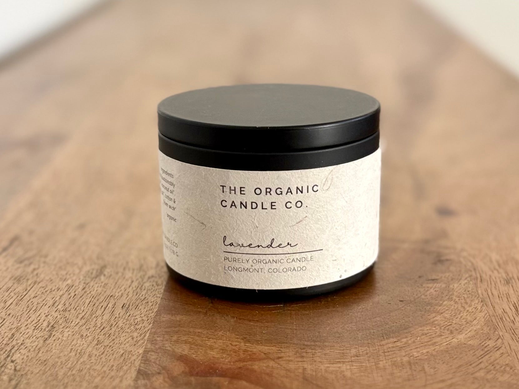 Candle jar from The Organic Candle Co. on a wooden surface