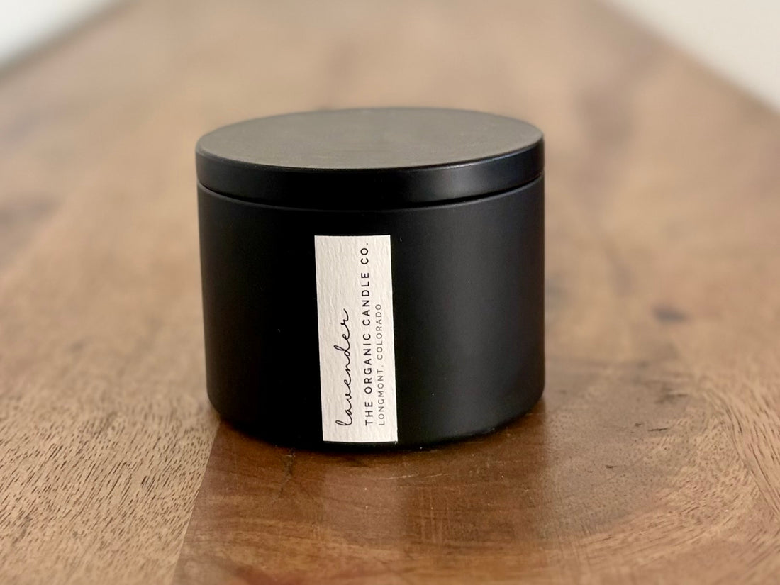 Organic candle in black tin on a wooden surface