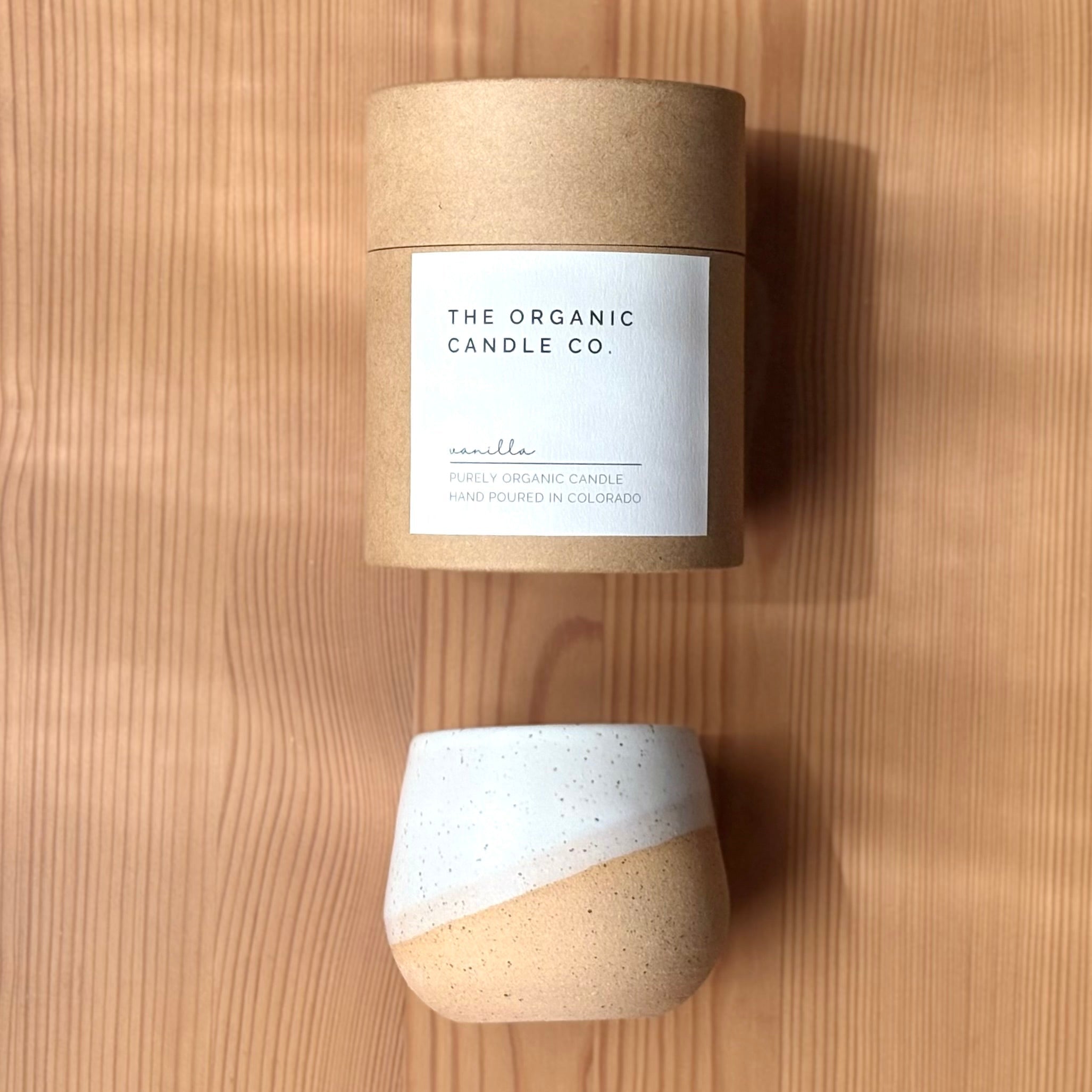 Candle with a cardboard sleeve labeled &