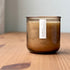 Organic candle in rose recycled glass jar on a wooden background. A label reads "gardenia; The Organic Candle Co."