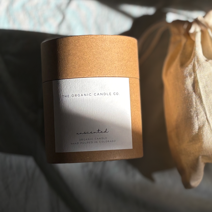 A kraft paper jar candle with a white label reading &